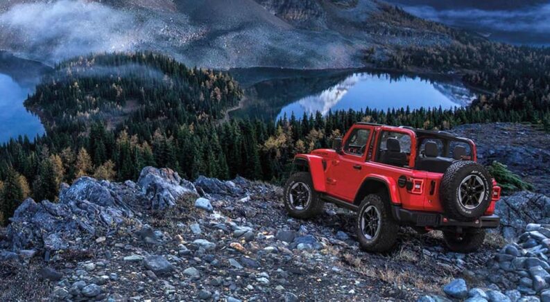 A red 2020 Jeep wrangler is shown parked near a cliff.