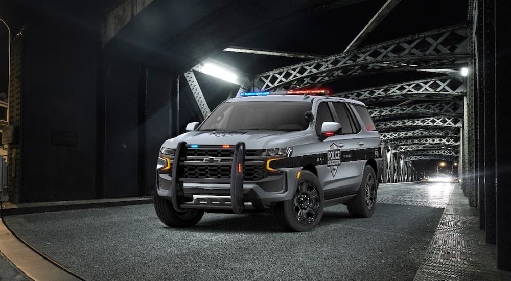 A black and grey 2021 Chevy Tahoe PPV is shown parked on a bridge.