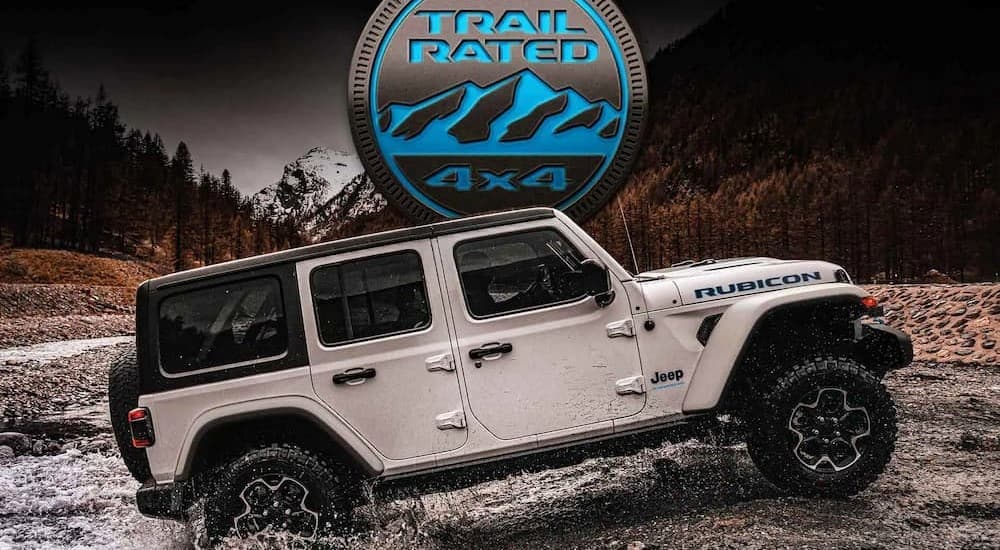 A white 2023 Jeep Wrangler 4xe Rubicon is shown driving off-road.