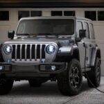 A silver 2023 Jeep Wrangler 4xe is shown charging after visiting a Jeep dealer.