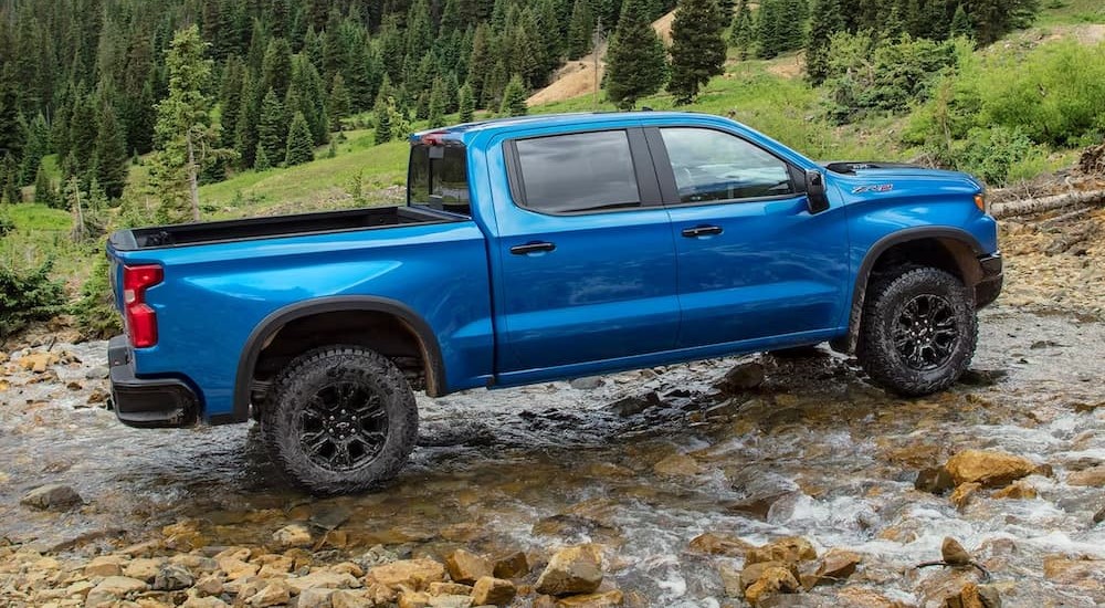 A blue 2024 Chevy Silverado 1500 ZR2 is shown parked off-road.