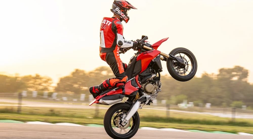 A person is shown riding a 2024 Ducati Hypermotard 698 Mono on a track.