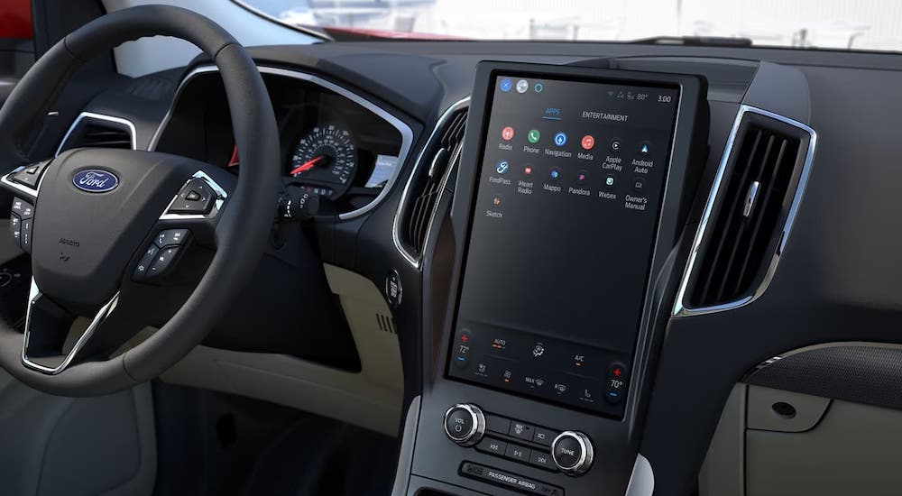 The black interior of a 2024 Ford Edge is shown, featuring a large dashboard interface.