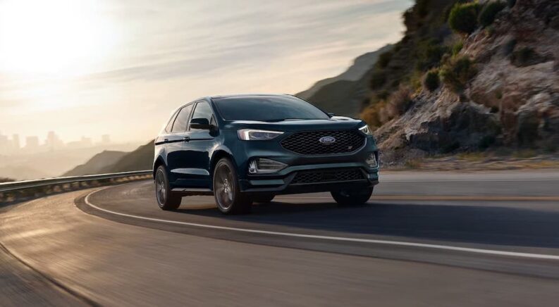 A black 2024 Ford Edge is shown driving.