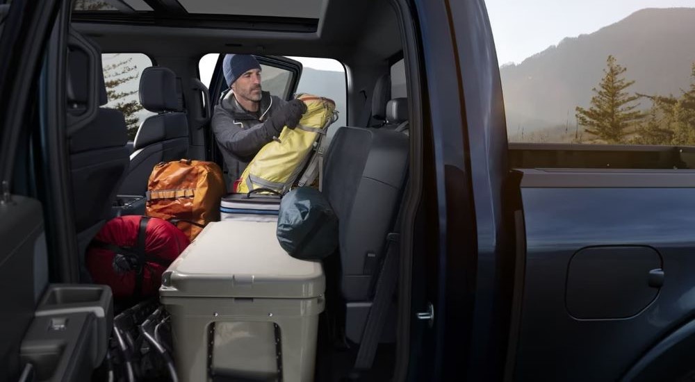 A person is shown loading supplies into the back of a 2024 Ford F-150 Platinum.
