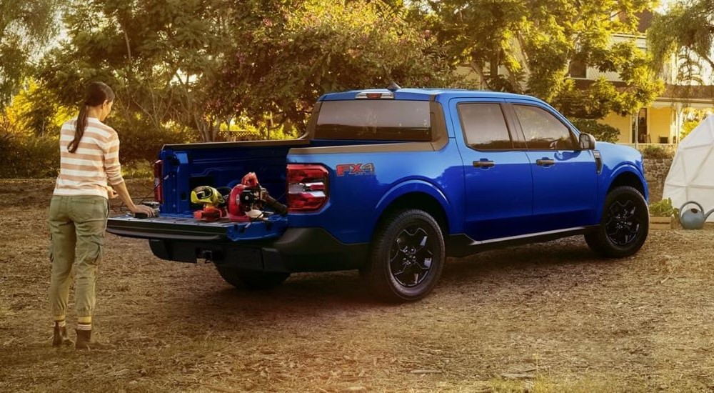 A blue 2024 Ford Maverick XLT is shown with power tools on the bed.