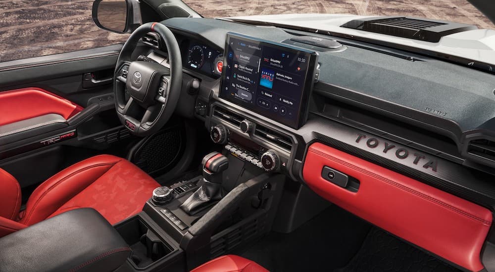 The black and red interior of a 2024 Toyota Tacoma is shown.