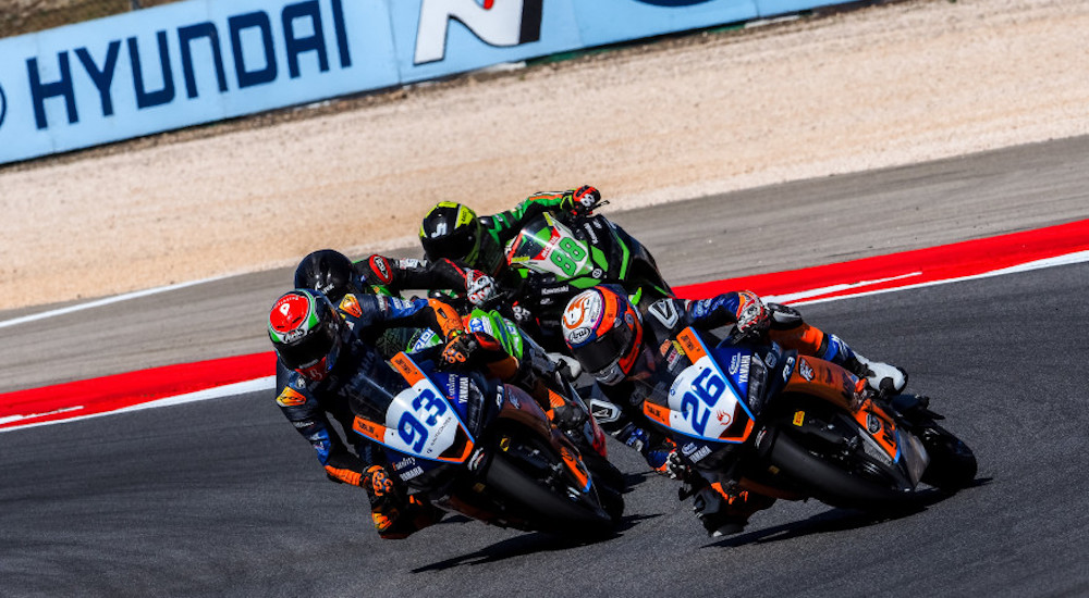 A team of motorcyclists are shown racing at a World Superbike event.