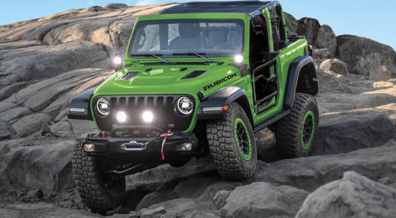 A green 2018 Jeep Wrangler Rubicon JL is shown driving off-road.