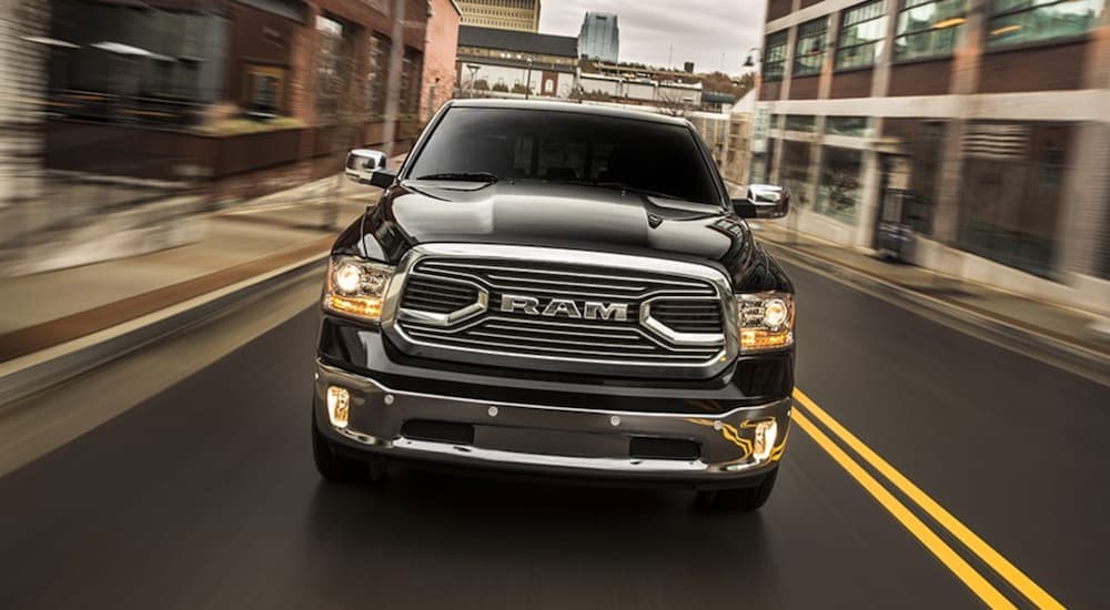 A black 2018 Ram 1500 is shown driving on a city street.