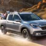 A silver 2019 Honda Ridgeline is shown driving off-road after viewing used trucks for sale.