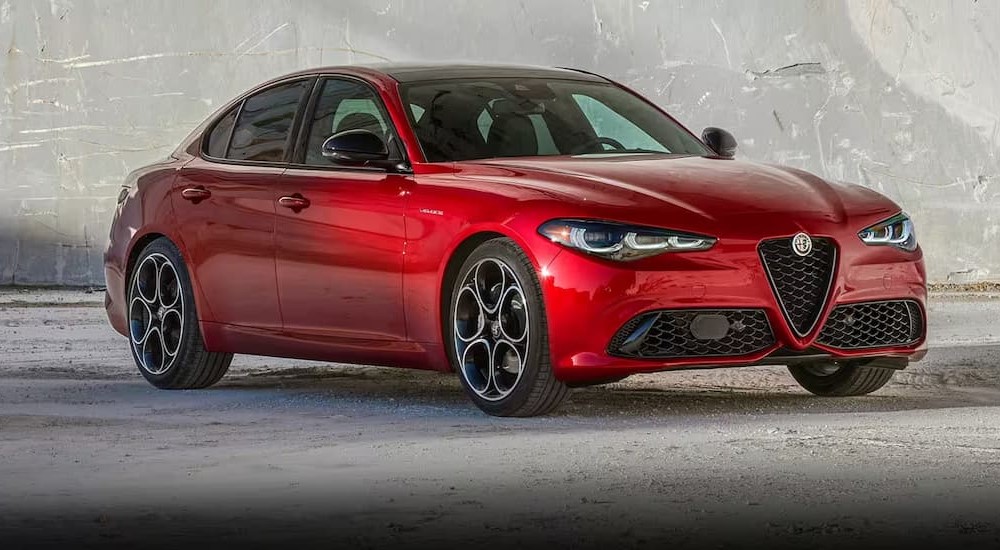 A red 2024 Alfa Romeo Giulia is shown parked near a wall.