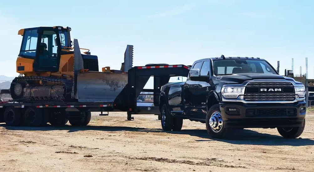 A black 2024 Ram 3500 is shown towing a trailer.
