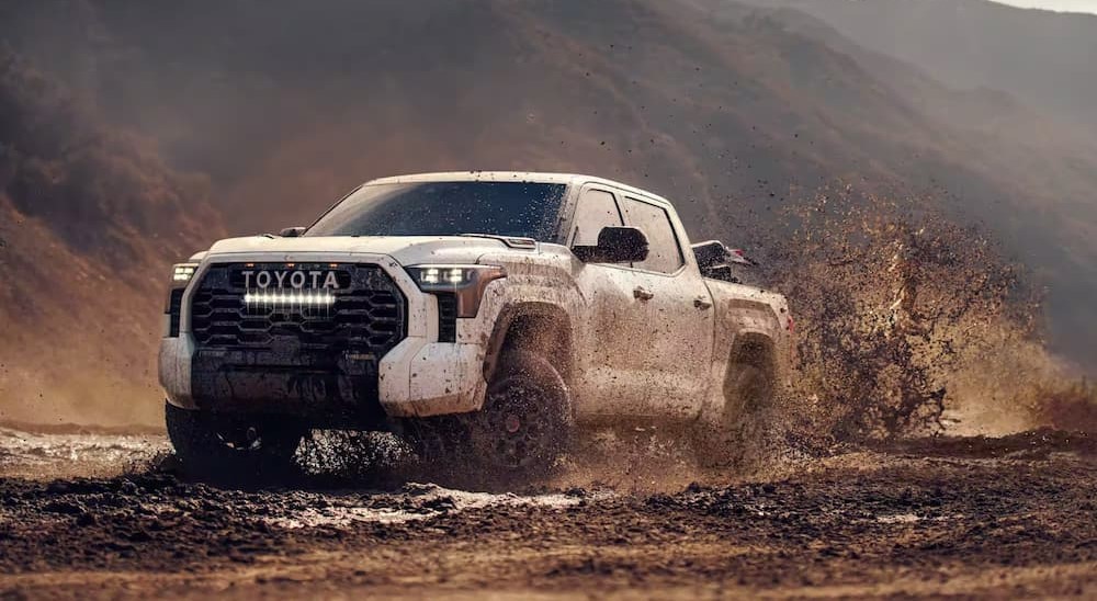 A white 2024 Toyota Tundra TRD Pro is shown driving off-road after visiting a Toyota Tundra dealer.