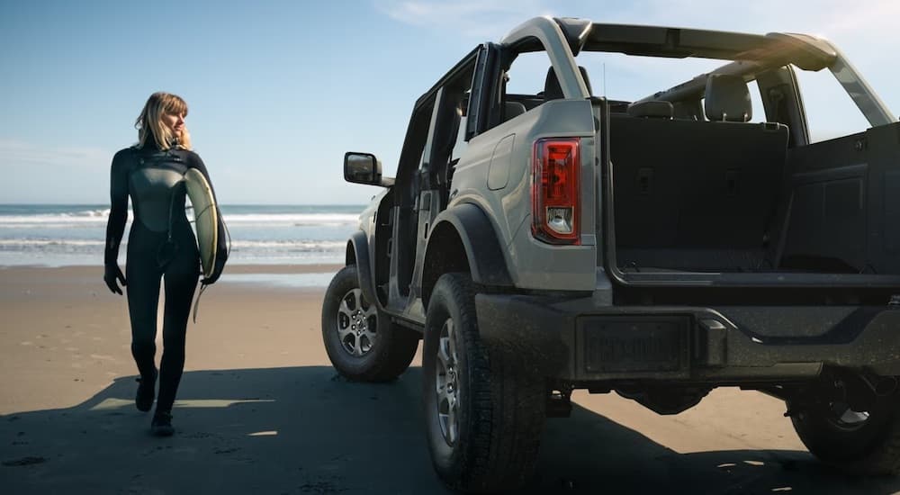 A beige 2022 Ford Bronco is shown parked on a beach.
