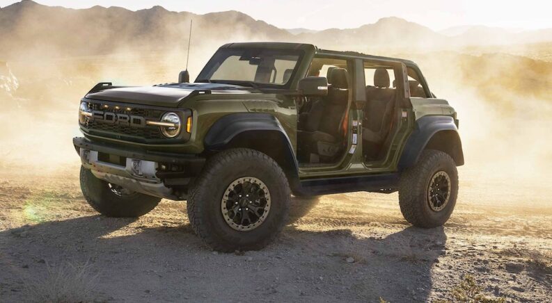 A dark green 2024 Ford Bronco Raptor is shown parked off-road.