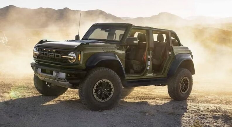 A green 2024 Ford Bronco Raptor is shown parked off-road.