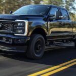 A black 2024 Ford Super Duty F-450 is shown driving.