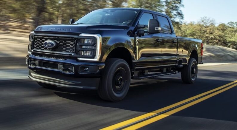 A black 2024 Ford Super Duty F-450 is shown driving.
