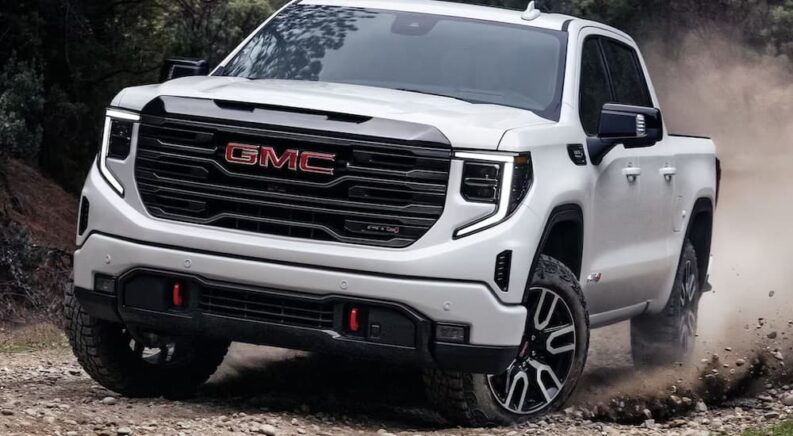 A popular type of Sierra 1500 for sale, a white 2024 GMC Sierra 1500 AT4, is shown driving off-road.