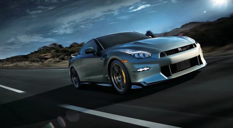 A blue 2024 Nissan GT-R is shown driving away from a local Nissan dealer.