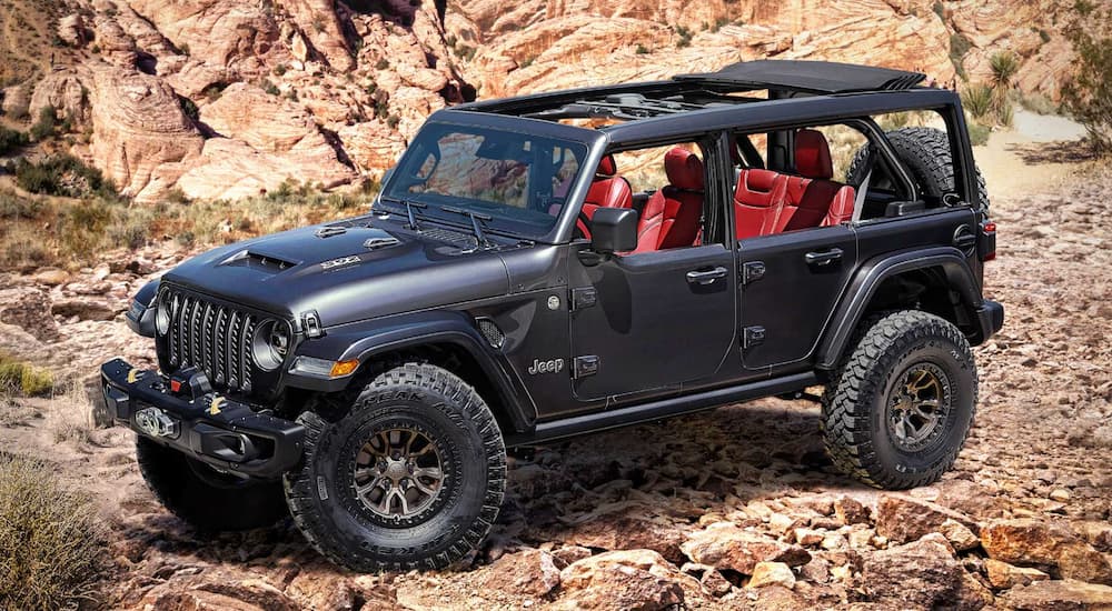 A black 2024 Jeep Wrangler Rubicon 392 is shown parked off-road.