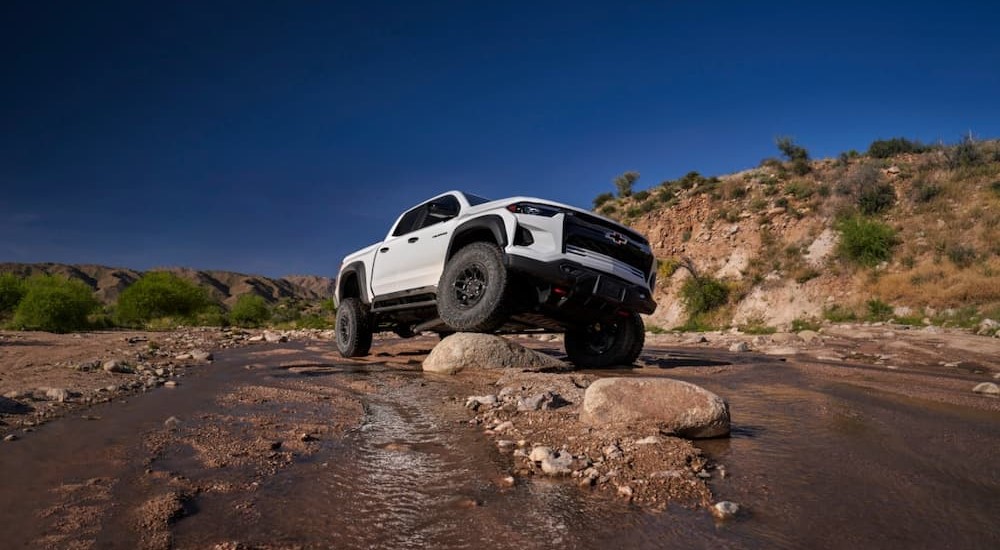 A white 2024 Chevy Colorado Bison ZR2 Bison is shown parked on a boulder.