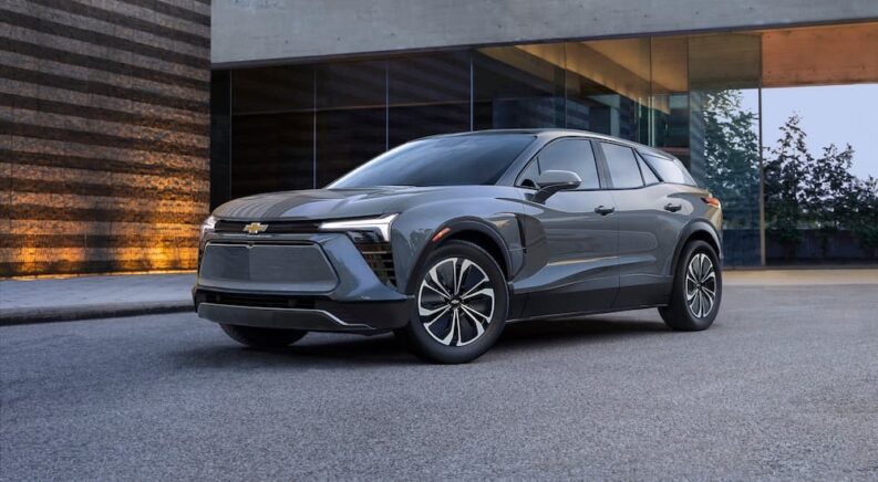 A gray 2024 Chevy Blazer EV for sale is shown parked near a building.