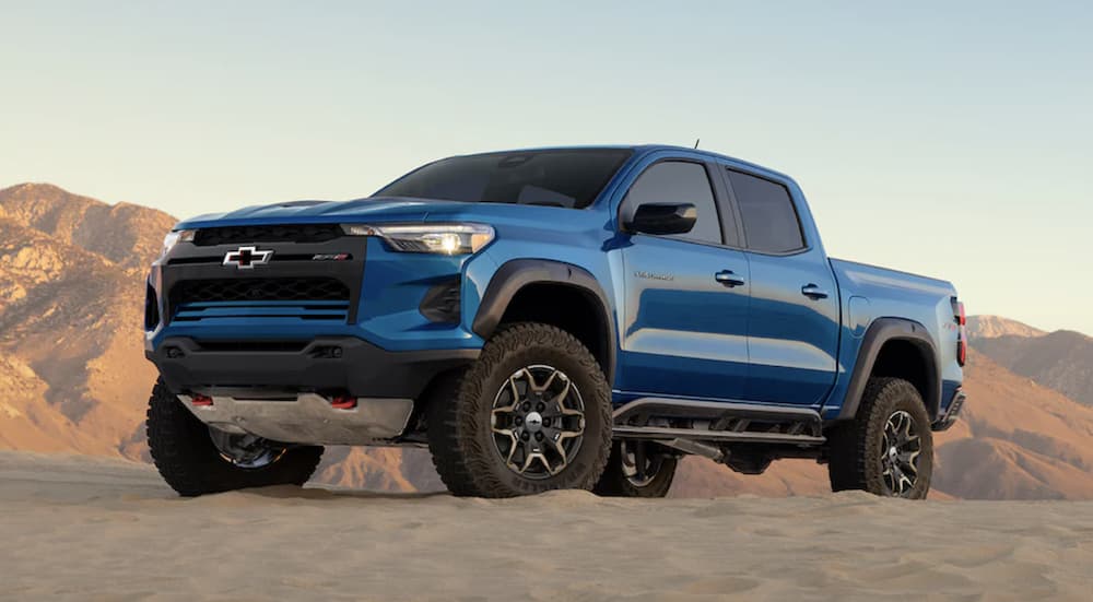 A blue 2024 Chevy Colorado ZR2 is shown parked on sand.