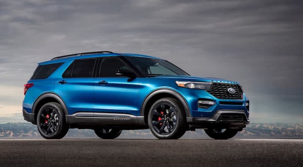 A blue 2020 Ford Explorer ST in front of a cloudy grey sky.