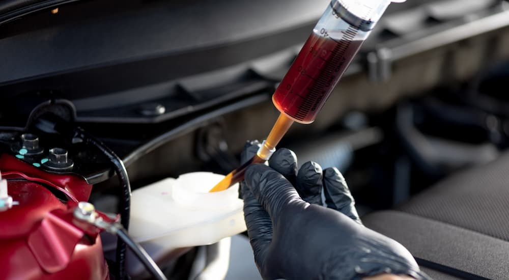 A mechanic adding brake fluid to a car during a brake service appointment.