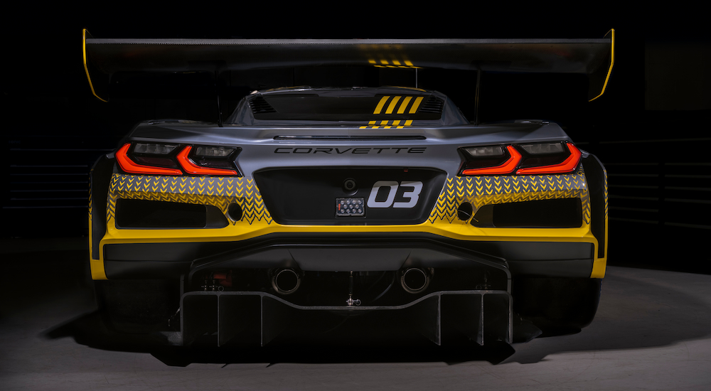 Rear view of a grey and yellow Chevy Corvette Z06 GT3.R in low lighting.