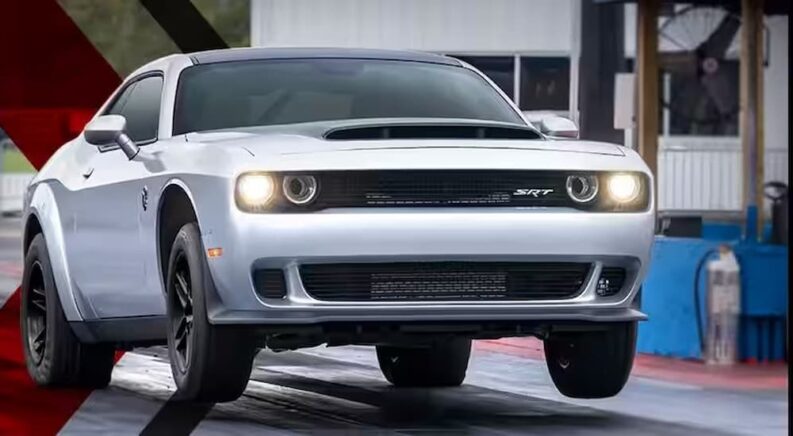 A white 2023 Dodge Challenger SRT Demon 170 is shown driving on a racetrack after visiting a used Dodge dealership.