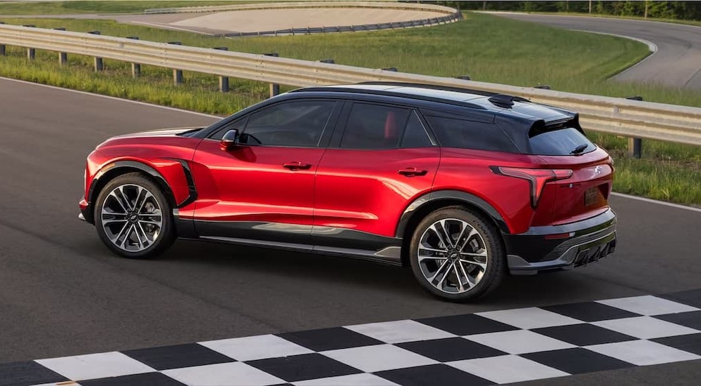 A red 2024 Chevy Blazer EV SS is shown driving on a racetrack.