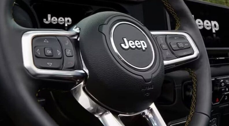 A close-up of the steering wheel in a 2024 Jeep Gladiator is shown.