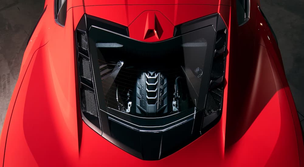 A close up of the engine and top of a red 2024 Chevy Corvette Stingray 3LT.