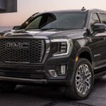 A black 2024 GMC Yukon Denali Ultimate parked in a driveway.