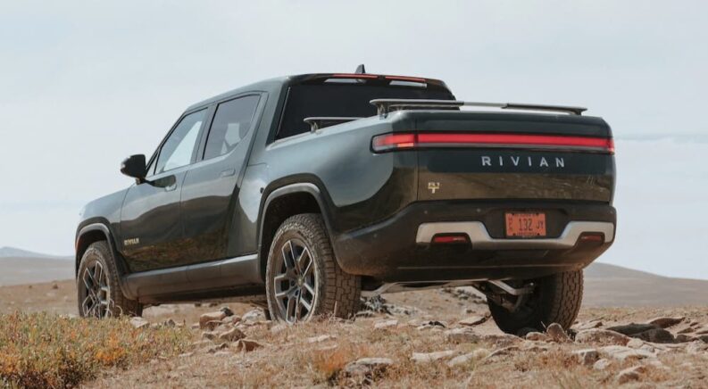 A green 2024 Rivian R1T is shown parked off-road.