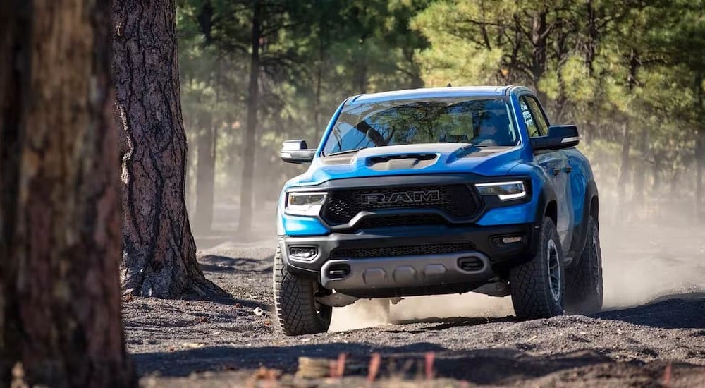 A blue 2023 Ram 1500 TRX is shown driving off-road.