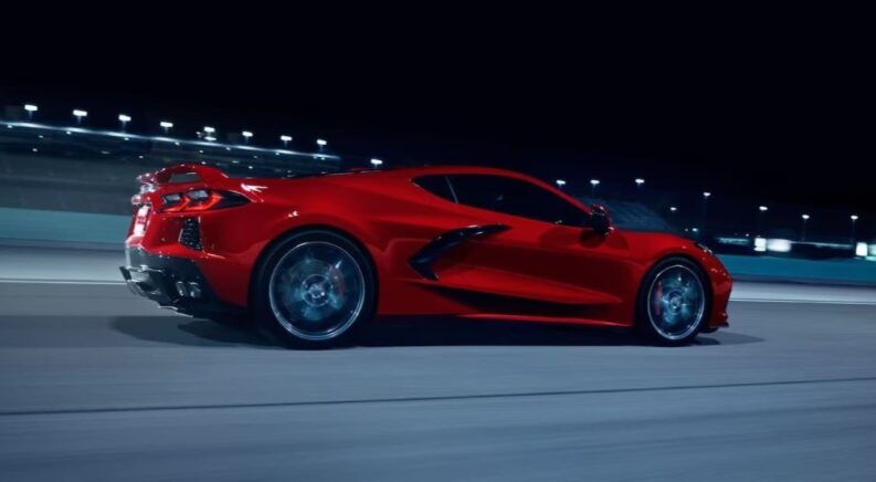 A red 2024 Chevy Corvette Stingray Z51 driving down a track at night.