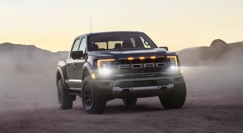 A popular Ford F-150 for sale, a gray 2024 Ford F-150 Raptor is shown parked with headlights on.