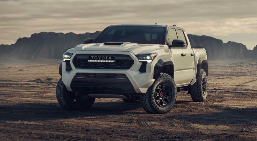 A white 2024 Toyota Tacoma TRD Pro driving off-road.