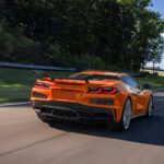 An orange 2023 Chevy Corvette Z06 is shown on a racetrack after leaving a Chevy dealer.