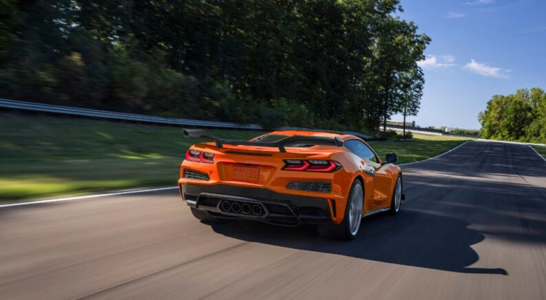 An orange 2023 Chevy Corvette Z06 is shown on a racetrack after leaving a Chevy dealer.
