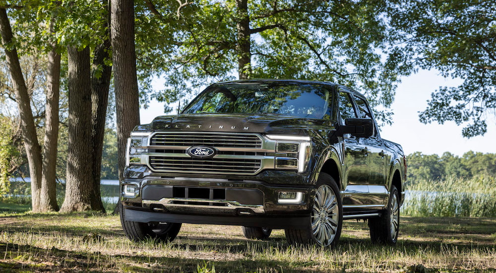 A tan 2024 Ford F-150 Platinum Plus is shown from the front at an angle after leaving a dealer that has trucks for sale.