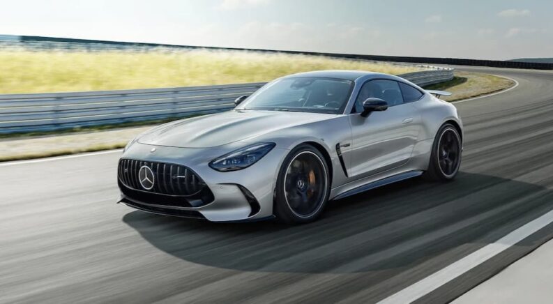 A silver 2024 Mercedes-AMG GT is shown driving on a racetrack.