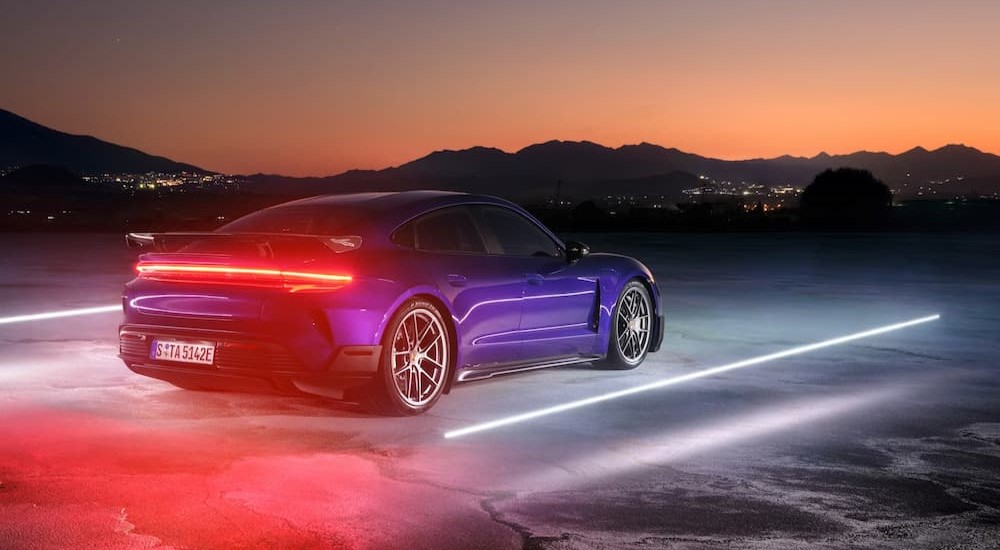 A purple 2025 Porsche Taycan Turbo GT is shown driving at night.