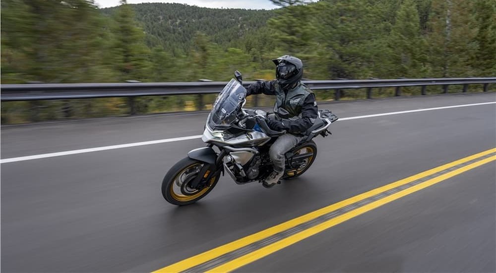 A silver 2023 CFMOTO IBEX 800 T is shown driving on a highway.