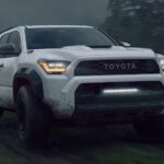 A white 2025 Toyota 4Runner TRD Pro is driving through a muddy trail.