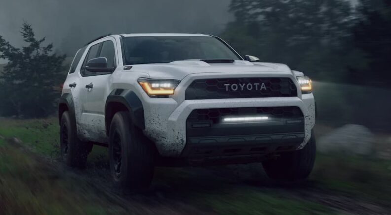 A white 2025 Toyota 4Runner TRD Pro is driving through a muddy trail.